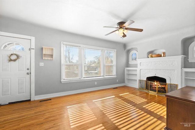 unfurnished living room with hardwood / wood-style flooring, a fireplace, and ceiling fan