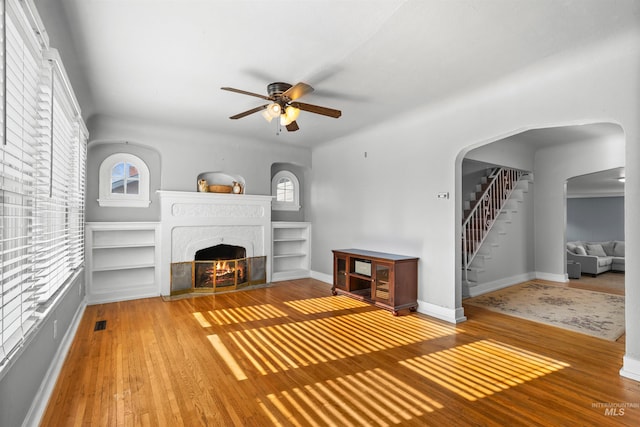 unfurnished living room with ceiling fan and hardwood / wood-style floors