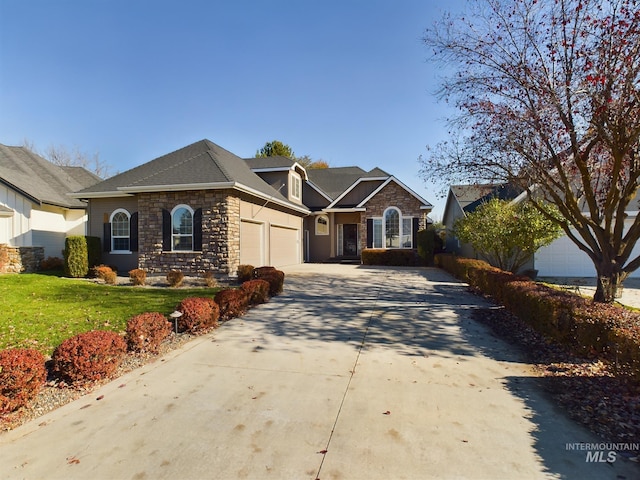 view of front of house with a garage, stone siding, concrete driveway, and a front yard