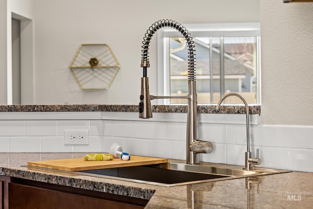 room details with a sink, decorative backsplash, and dark brown cabinetry