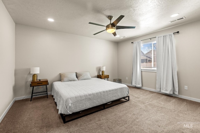 bedroom with visible vents, a textured ceiling, carpet, baseboards, and ceiling fan