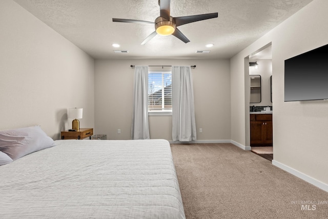 bedroom with connected bathroom, baseboards, light colored carpet, a textured ceiling, and a ceiling fan