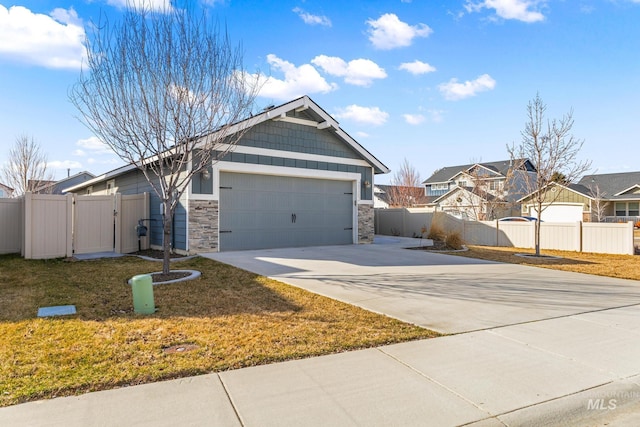 view of front of property with a front lawn, a gate, fence, board and batten siding, and concrete driveway