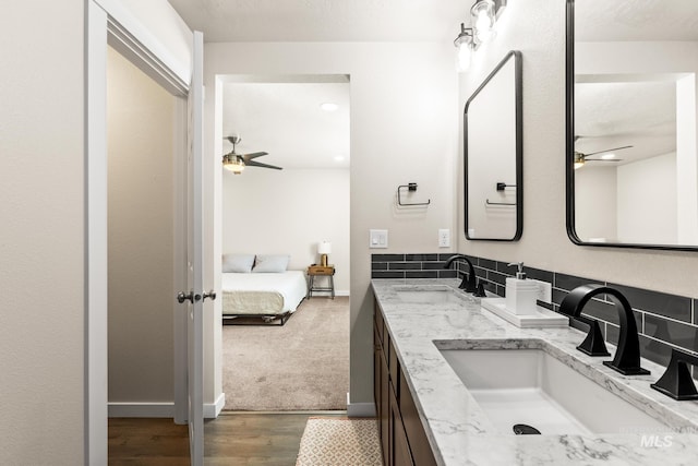 bathroom featuring a ceiling fan, ensuite bathroom, and a sink