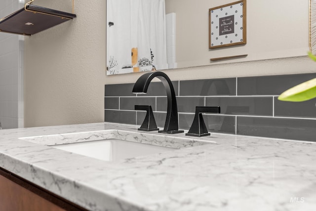 interior details featuring vanity and a textured wall