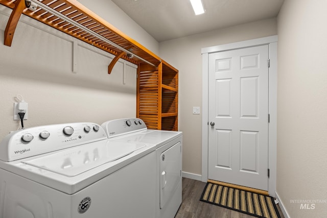 laundry room with baseboards, separate washer and dryer, dark wood-style floors, and laundry area