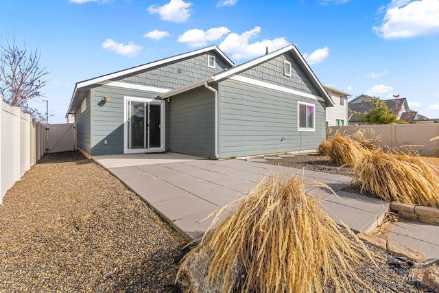 rear view of house featuring a patio and a fenced backyard