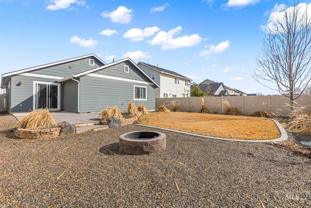 back of property with a patio area, an outdoor fire pit, and fence