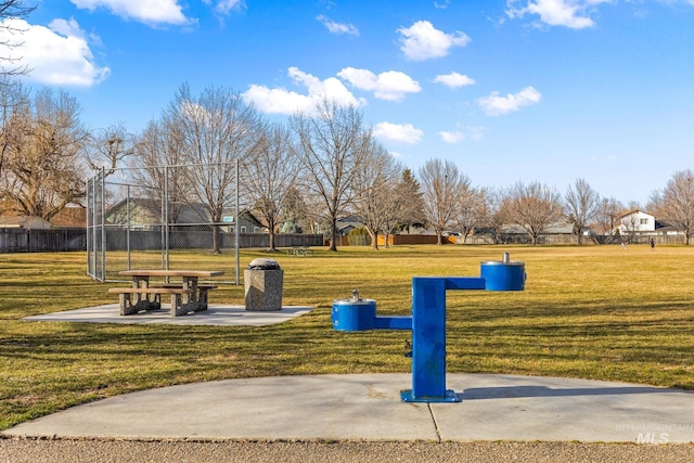 view of property's community with a lawn and fence