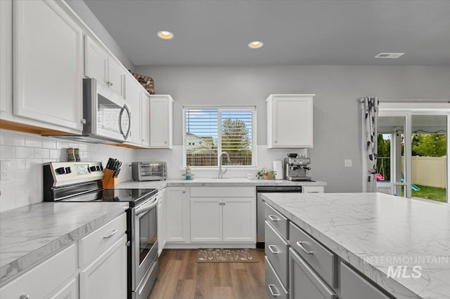 kitchen featuring dark wood-style floors, plenty of natural light, appliances with stainless steel finishes, and a sink