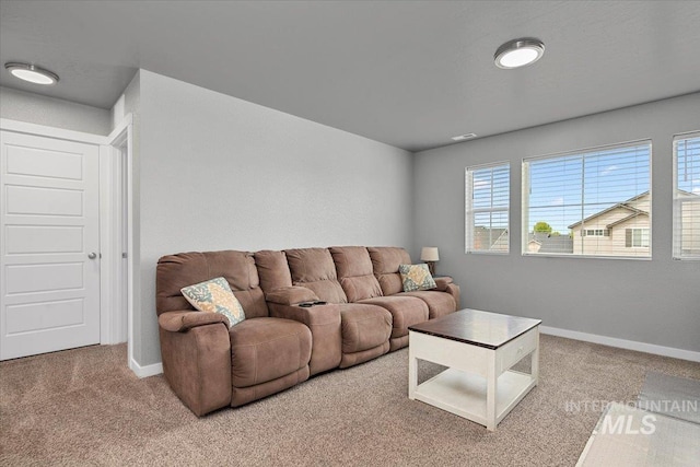 carpeted living area with baseboards