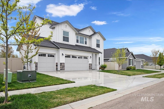 traditional-style home with board and batten siding, fence, a front lawn, concrete driveway, and an attached garage