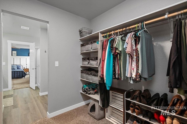 walk in closet with wood finished floors