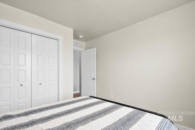 unfurnished bedroom featuring a closet, visible vents, and baseboards