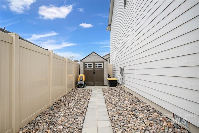 view of side of property with an outbuilding, a storage shed, and a fenced backyard