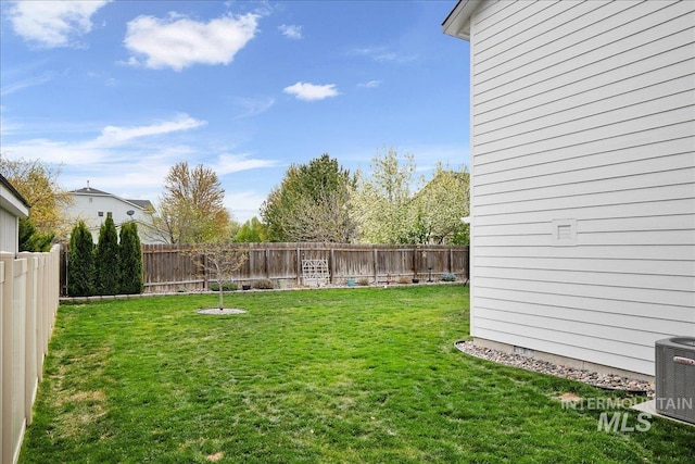 view of yard with central AC and a fenced backyard