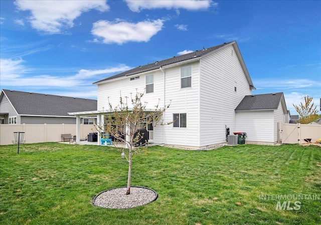 back of house with a fenced backyard, a yard, a gate, a patio, and central AC