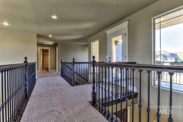 corridor with carpet, recessed lighting, an upstairs landing, and baseboards