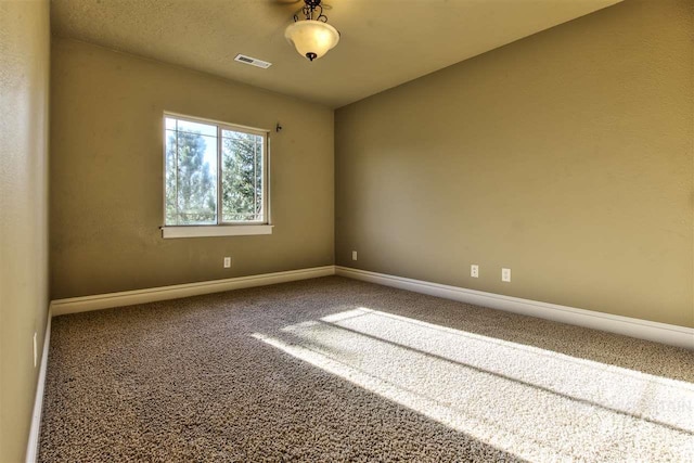 unfurnished room with visible vents, baseboards, and carpet