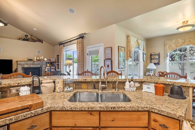 455 Coiner Cir, Twin Falls, ID 83301 - kitchen featuring open floor plan, a tile fireplace, light stone counters, and lofted ceiling