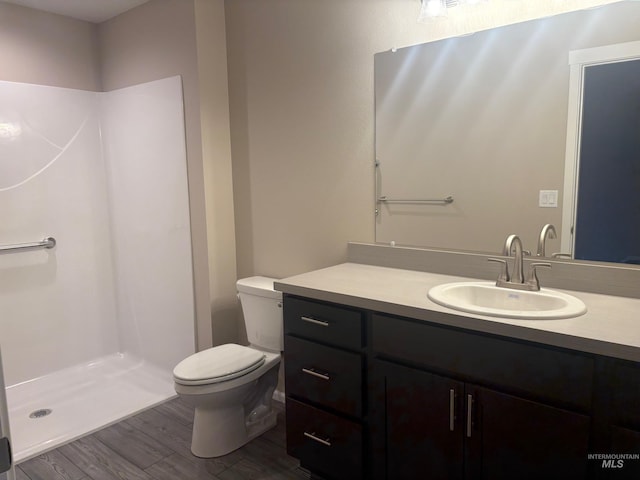 bathroom featuring toilet, a shower, vanity, and hardwood / wood-style floors
