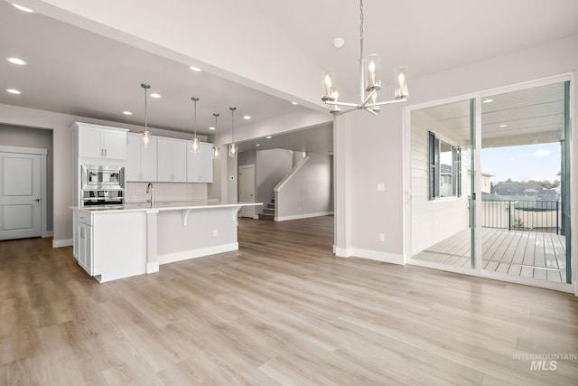 kitchen featuring white cabinetry, light countertops, appliances with stainless steel finishes, and light wood-type flooring