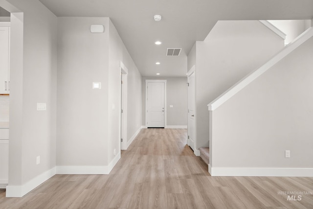 corridor featuring baseboards, visible vents, recessed lighting, and light wood finished floors