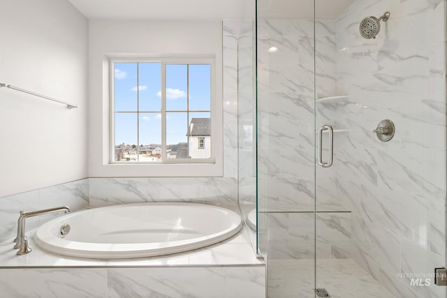 bathroom with a bath and a marble finish shower