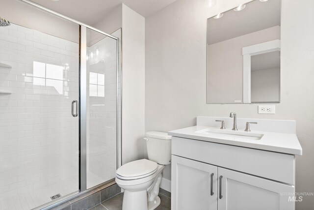 full bathroom featuring a stall shower, toilet, tile patterned flooring, and vanity