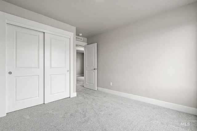 unfurnished bedroom featuring carpet flooring, a closet, baseboards, and visible vents