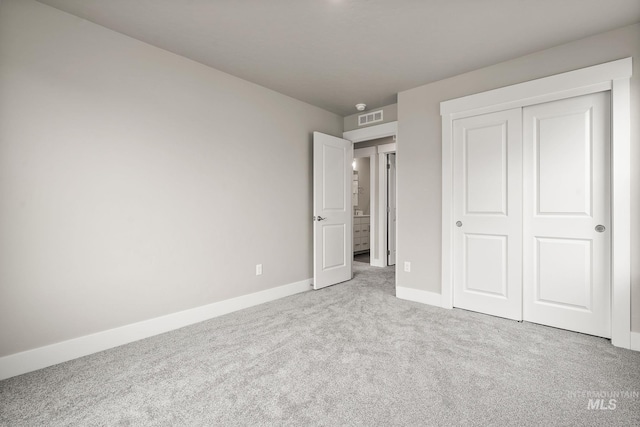 unfurnished bedroom featuring carpet flooring, a closet, baseboards, and visible vents