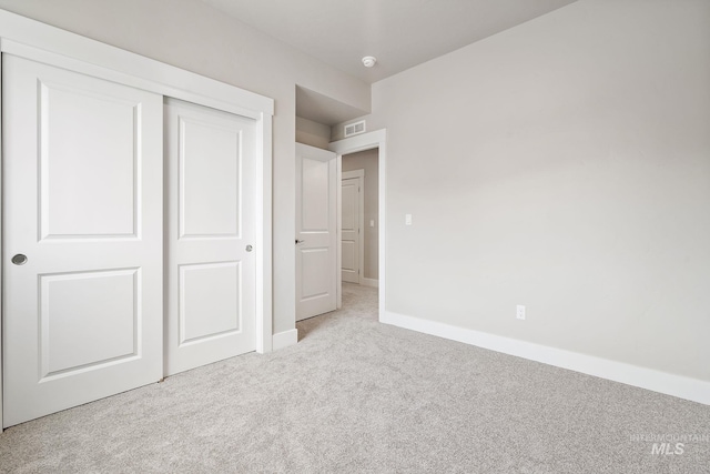 unfurnished bedroom with baseboards, visible vents, a closet, and carpet flooring