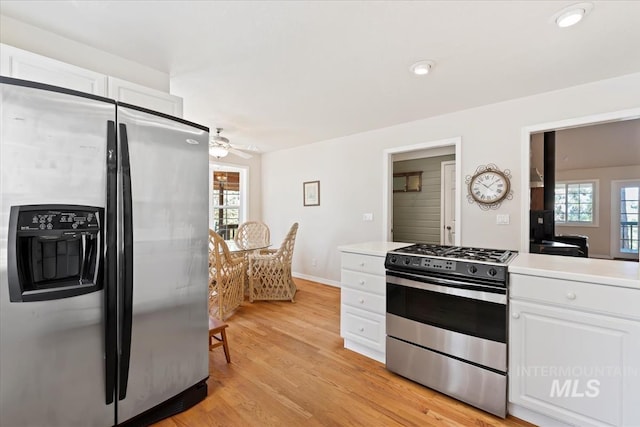 kitchen with a wealth of natural light, white cabinetry, a ceiling fan, and stainless steel appliances