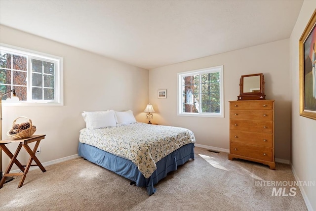 carpeted bedroom featuring baseboards and visible vents