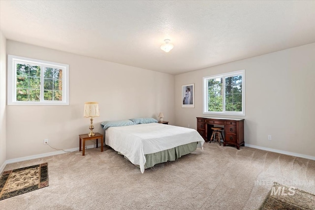 bedroom with baseboards, multiple windows, and light carpet