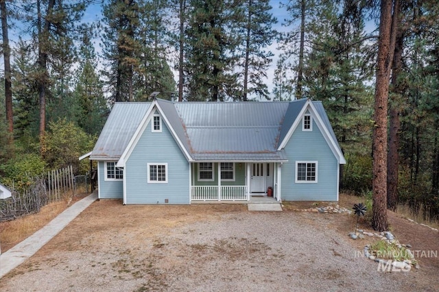 view of front of property with a porch, driveway, fence, and metal roof