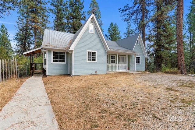 view of front of home with metal roof, concrete driveway, and a porch