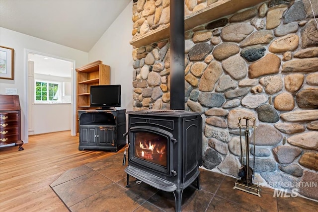 interior details with wood finished floors and a wood stove