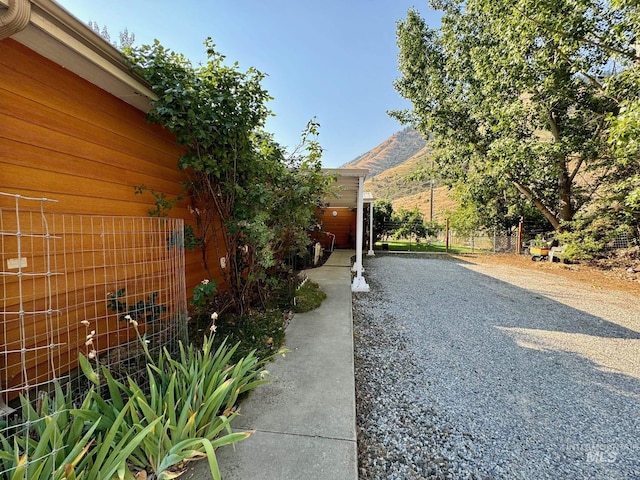 384 Race Creek Rd, Riggins, ID 83549 - view of side of home featuring fence, a mountain view, and gravel driveway