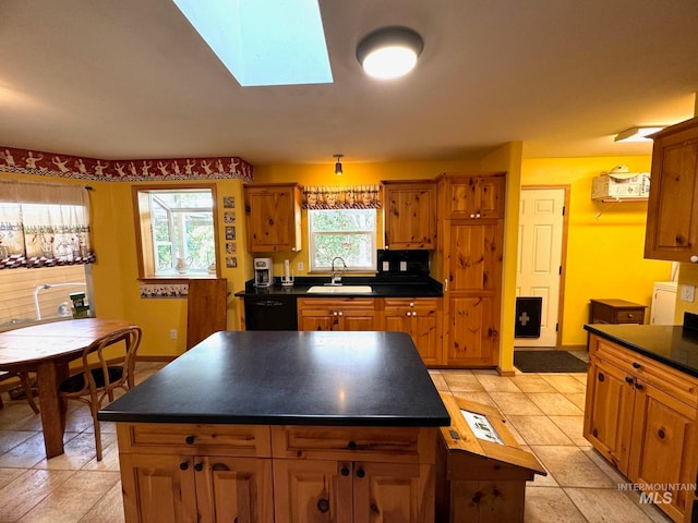 kitchen with light tile patterned flooring, a skylight, a center island, and dishwasher