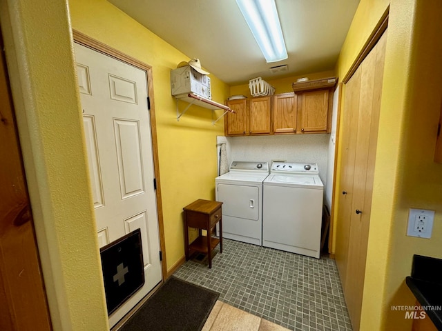 laundry area with cabinets, light tile patterned floors, and washer and dryer