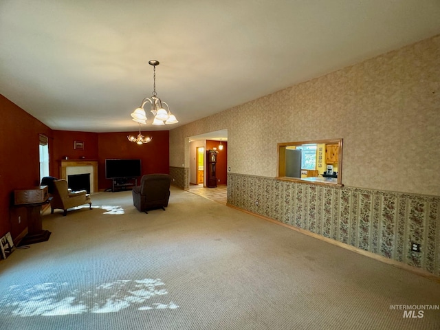 unfurnished living room featuring a notable chandelier and light carpet