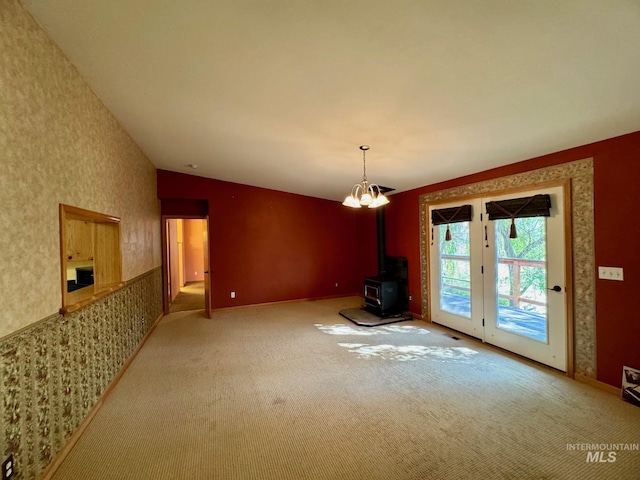 384 Race Creek Rd, Riggins, ID 83549 - unfurnished dining area featuring carpet flooring, wallpapered walls, baseboards, a wood stove, and lofted ceiling