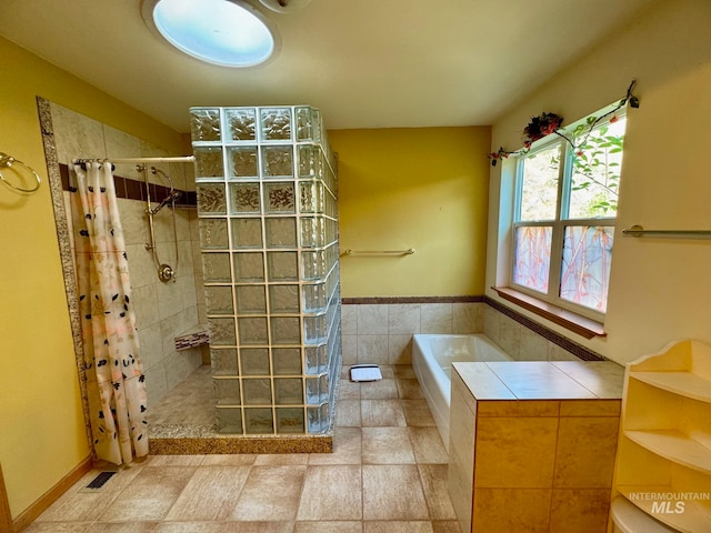 bathroom with separate shower and tub and tile patterned flooring