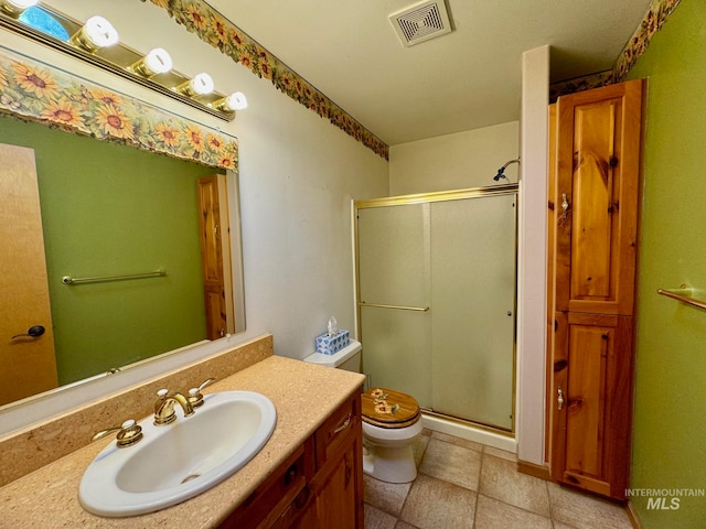 bathroom featuring an enclosed shower, vanity, toilet, and tile patterned flooring