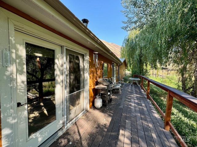 wooden deck featuring a grill