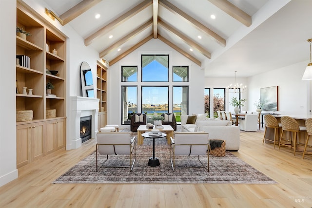 6203 W Estuary St, Eagle, ID 83616 - living area with beamed ceiling, a glass covered fireplace, a chandelier, plenty of natural light, and light wood finished floors