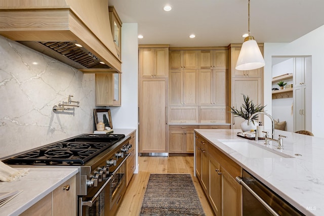 6203 W Estuary St, Eagle, ID 83616 - kitchen featuring custom range hood, stainless steel appliances, a sink, light wood finished floors, and light stone countertops