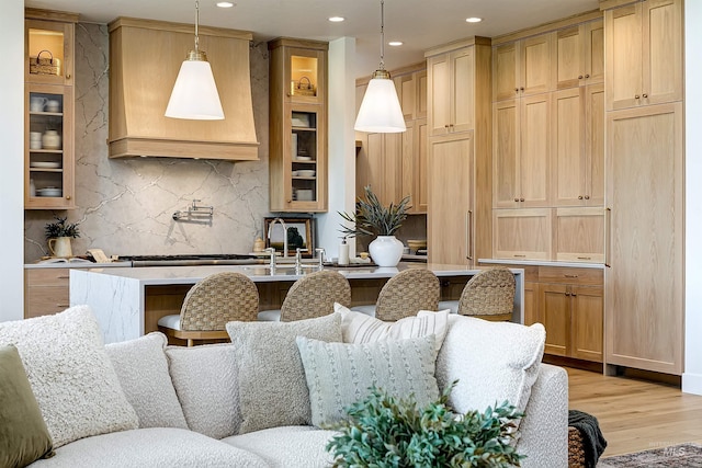 6203 W Estuary St, Eagle, ID 83616 - kitchen featuring a kitchen bar, light wood-type flooring, backsplash, recessed lighting, and premium range hood