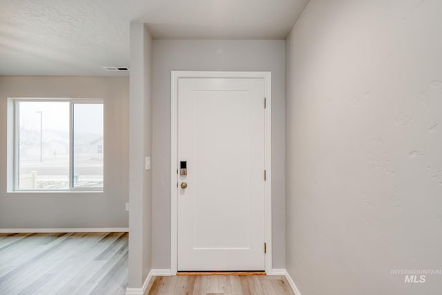 entryway with visible vents, baseboards, and light wood finished floors